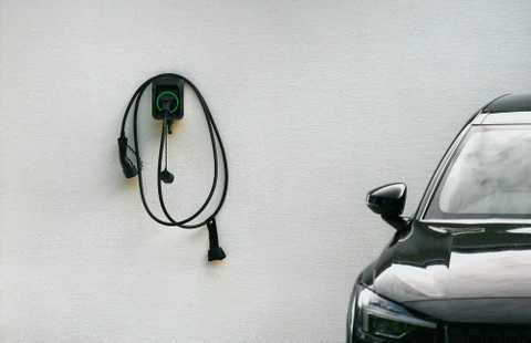 Porte-bouchon pour chargeur EV de montage mural. Station de chargement avec câble au mur fixé au mur de maison blanche. Concept d'avenir durable. Voitures électriques.